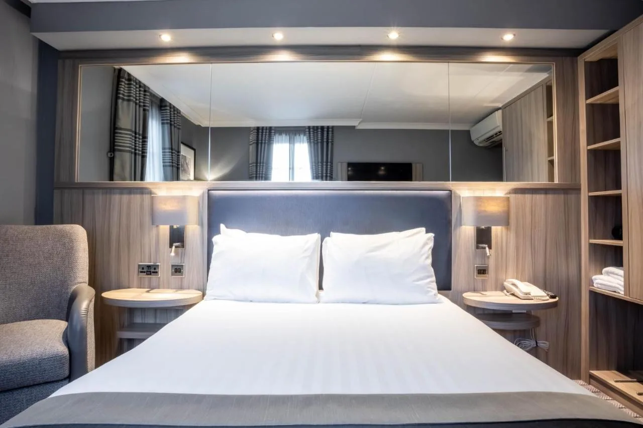 a bedroom with a bed and a chair and a mirror at Holiday Inn Glasgow City Theatreland by IHG in Glasgow