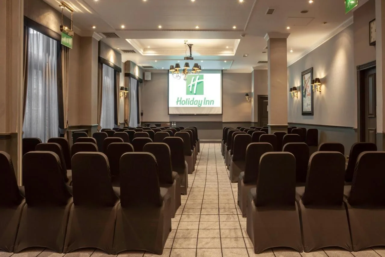 a lecture hall with chairs and a projection screen at Holiday Inn Glasgow City Theatreland by IHG in Glasgow