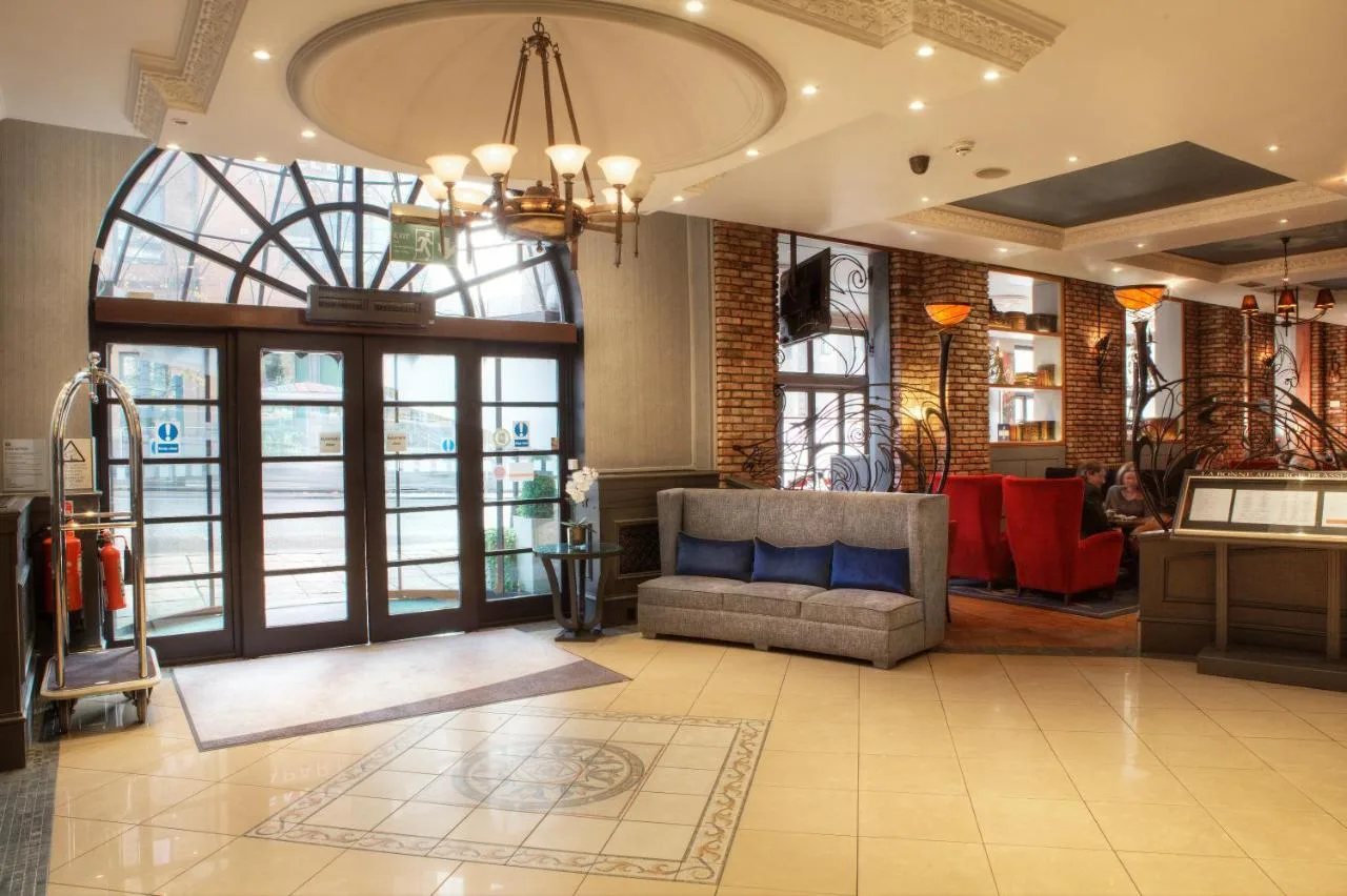 a living room with a couch and a large window at Holiday Inn Glasgow City Theatreland by IHG in Glasgow